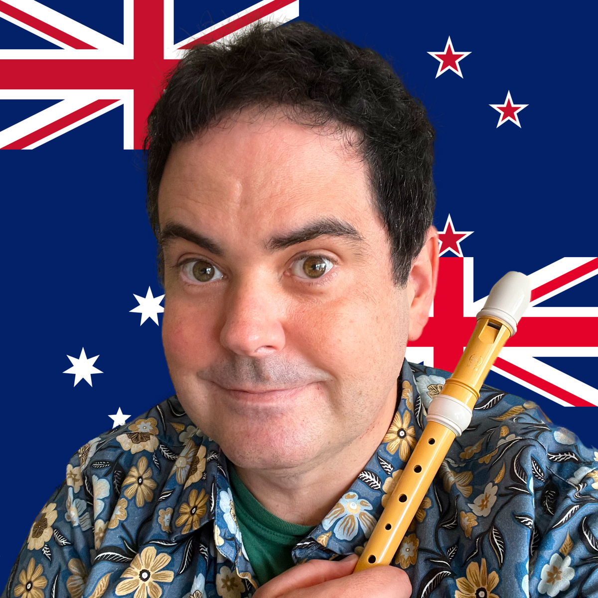 Richard holding a recorder with Australian and New Zealand flags in the background